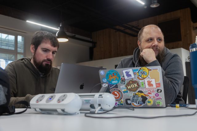 Two male members working with their laptops open
